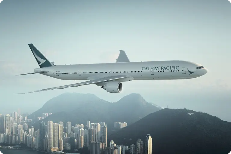 Airplane flying over city with "CATHAY PACIFIC" on the side